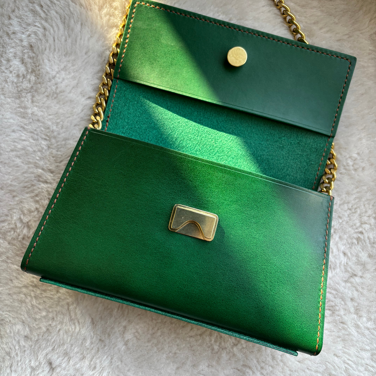 Interior of the two-tone green Icona leather shoulder bag with brass closure.