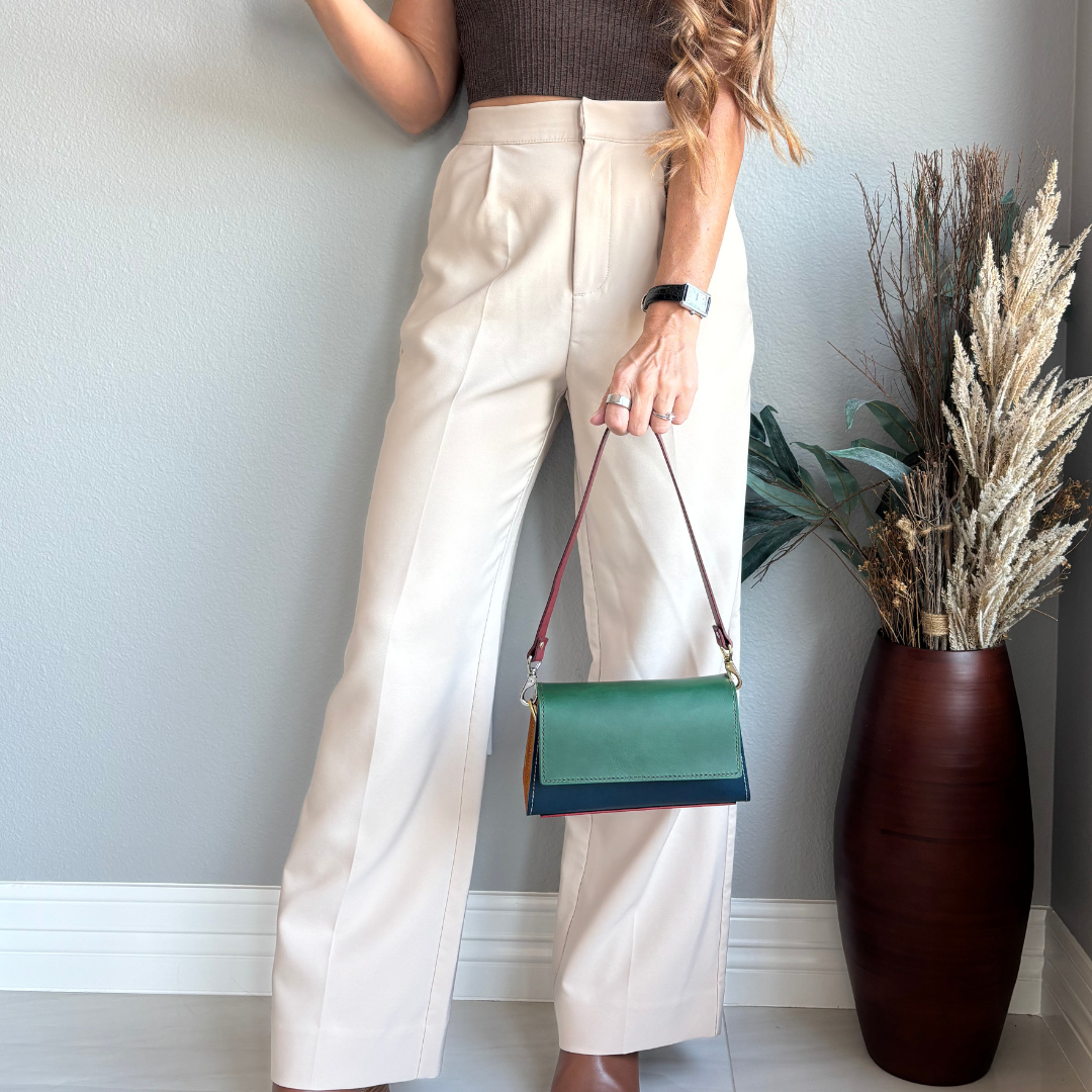 The Wild Card 2026 leather shoulder bag held at the side, showing the bag’s size and scale when carried.